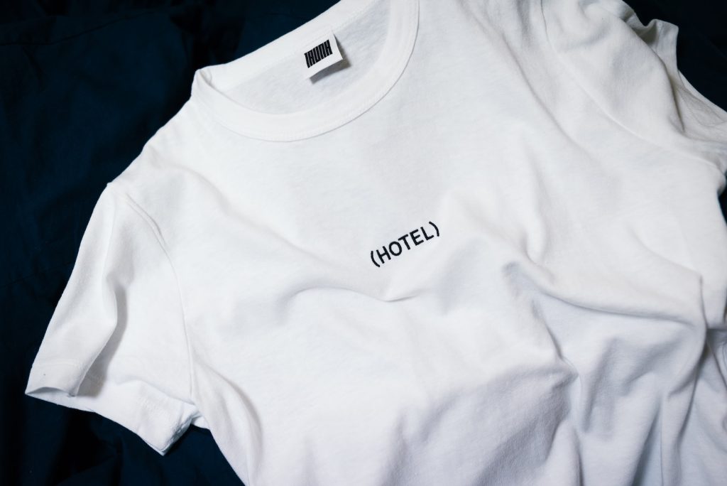 white hotel-printed crew-neck shirt on black surface